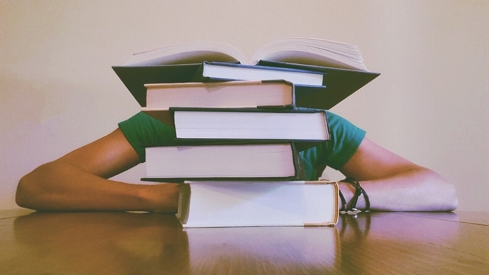 Boy with head down in books